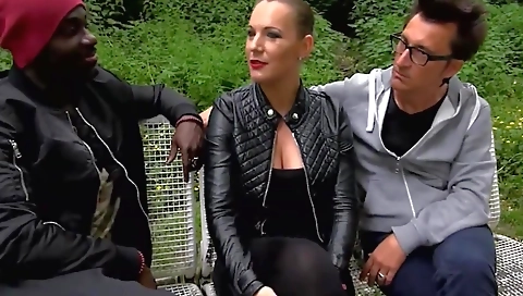 Ebony chick with a tattooed body is having outdoor threesome