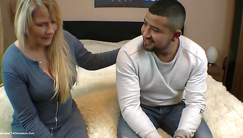 Blonde milf with big tits giving a blowjob to a guy